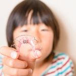 床矯正で使用する装置を持っている子供