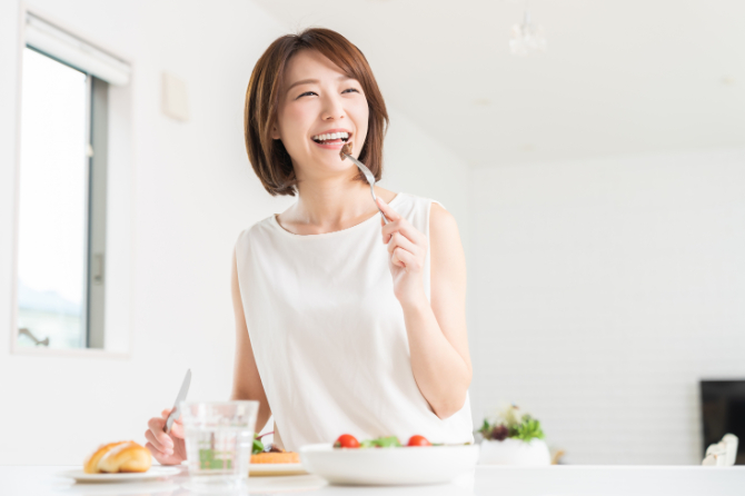 マウスピース矯正の保定期間に美味しく食事をする女性