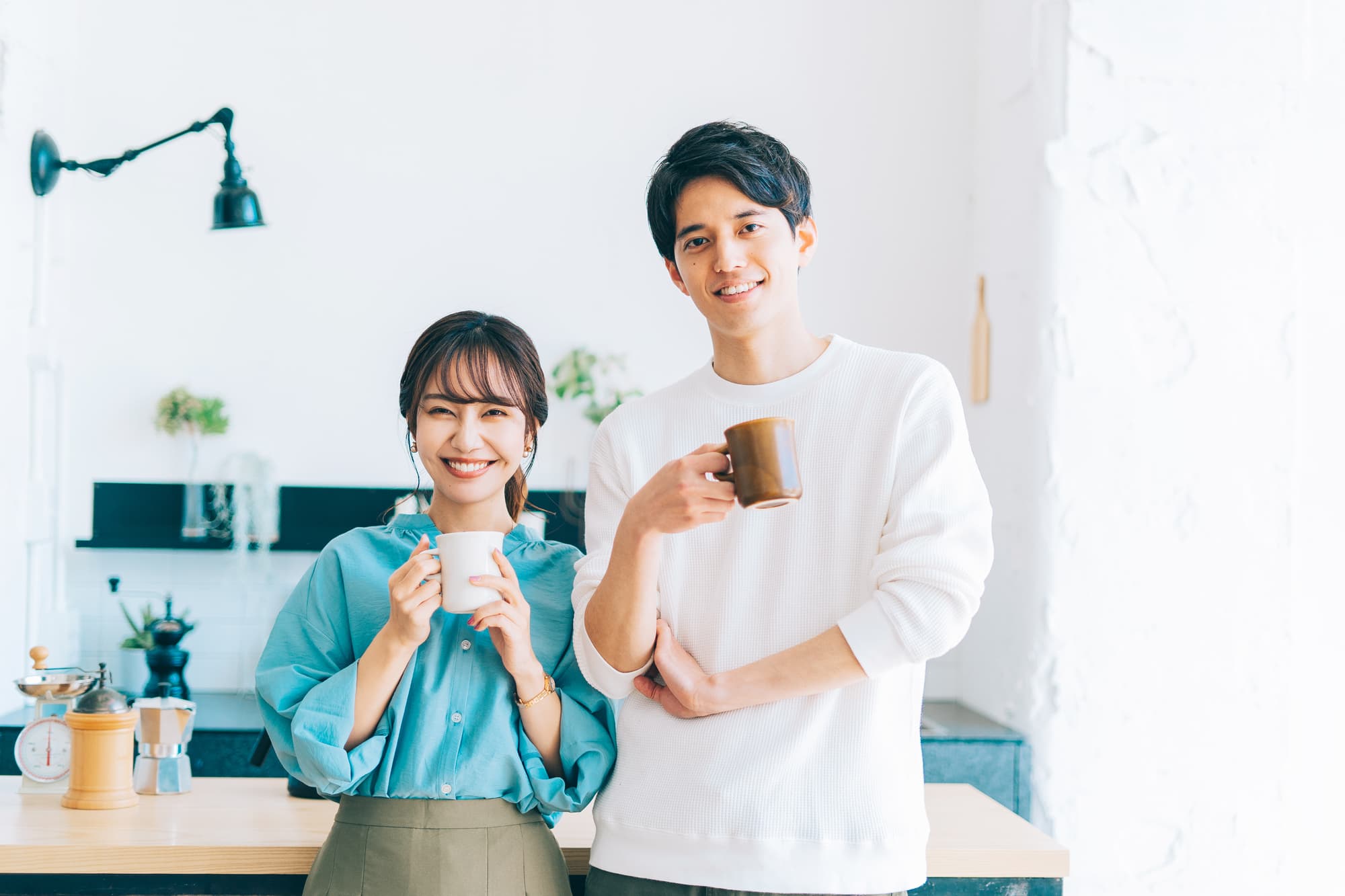 笑顔でマグカップを持ちリラックスする若い男女